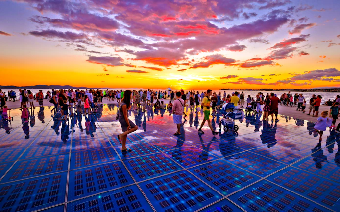 Crowd enjoying sunset at Sun installation, Zadar, Croatia.