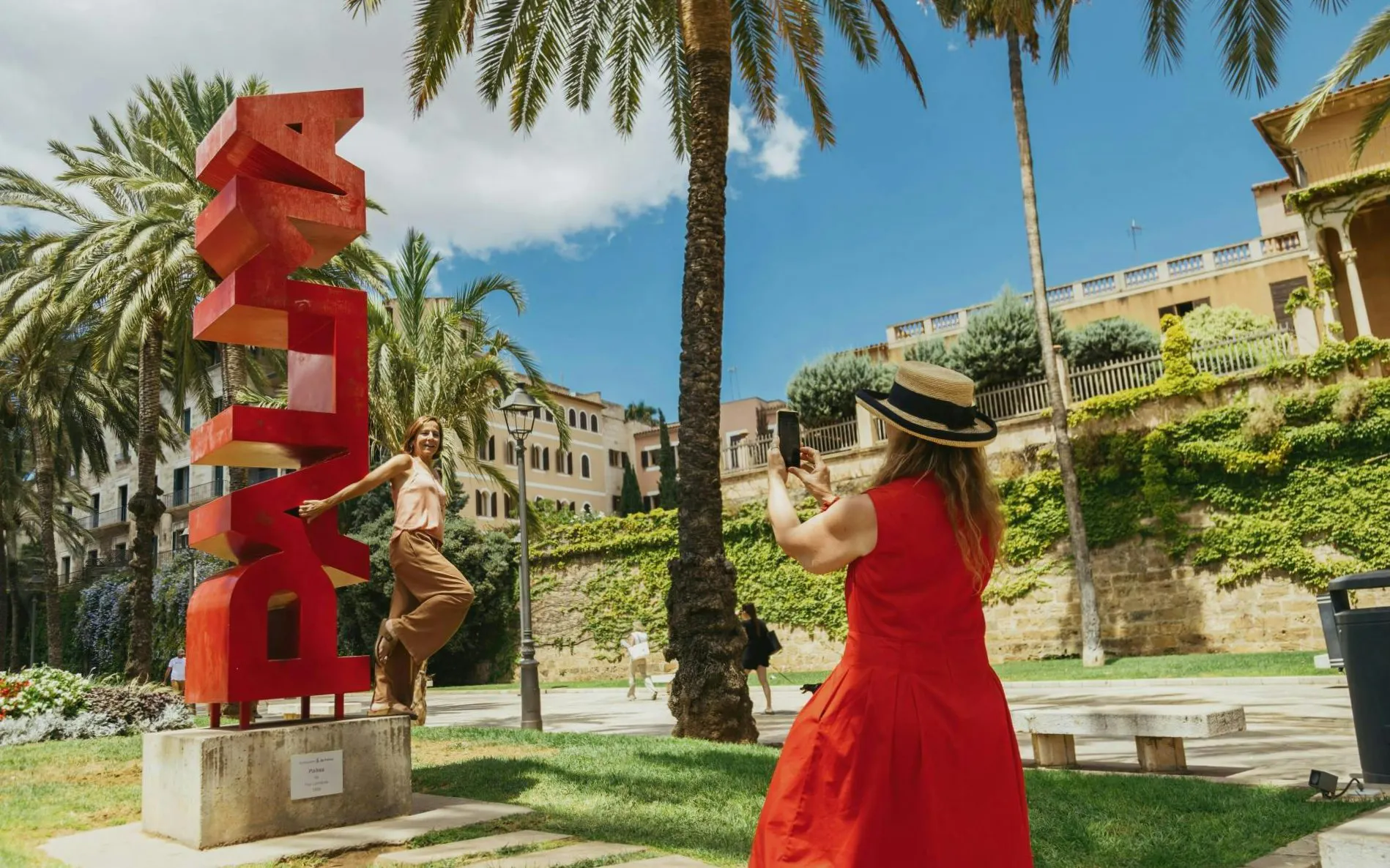 PALMA sculpture on Avinguda Gabriel Roca promenade, Palma de Mallorca, with tourists taking photos.