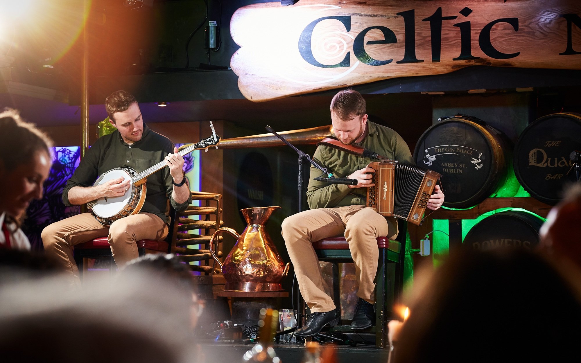 Musicians playing banjo and accordion at Dublin Celtic Nights show.