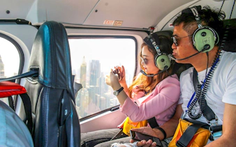 Couple enjoying aerial view of Dubai from helicopter.