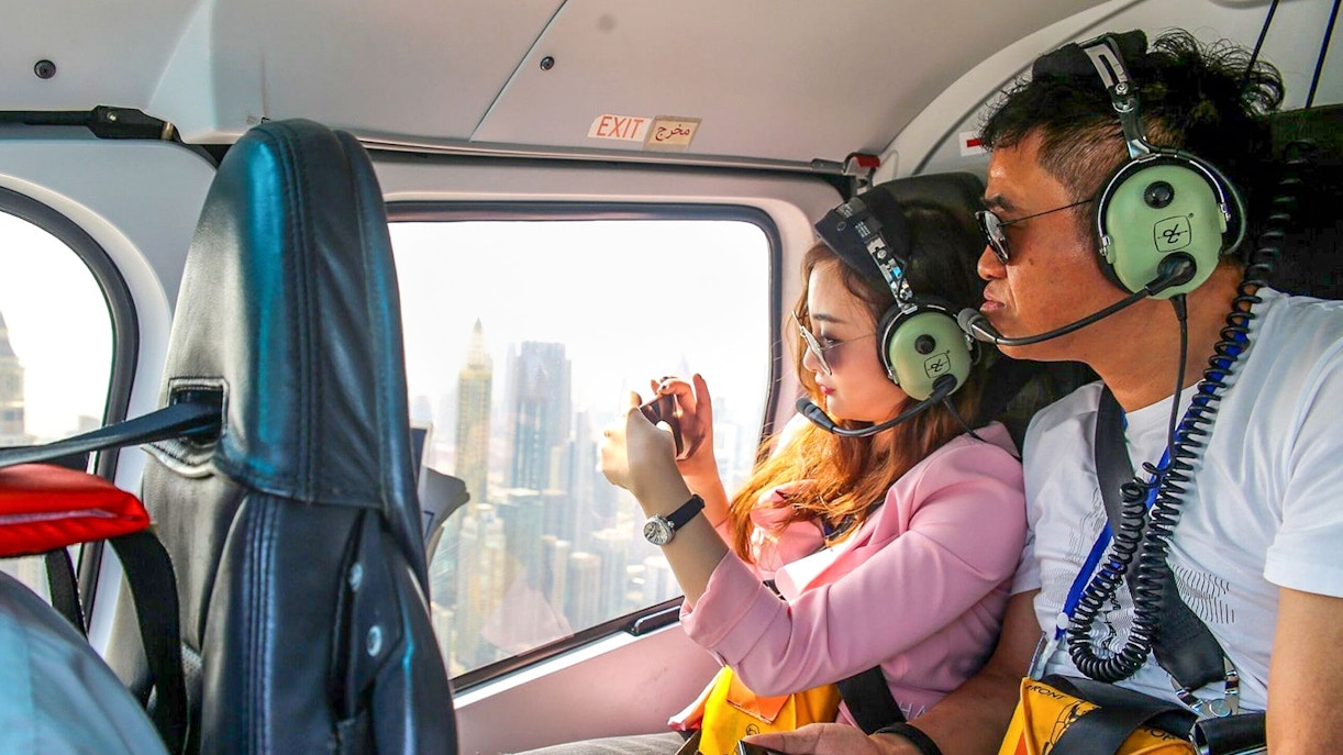 Couple enjoying aerial view of Dubai from helicopter.