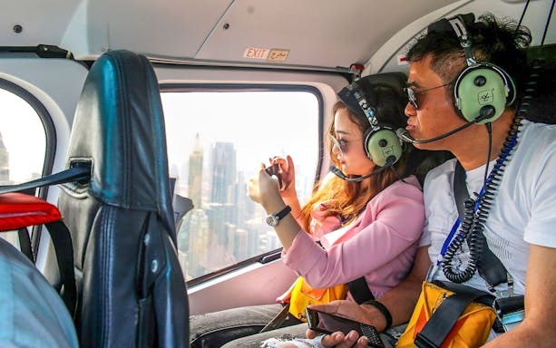 Couple enjoying aerial view of Dubai from helicopter.