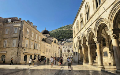 Stradun street with people walking near historic buildings in Dubrovnik Old Town.