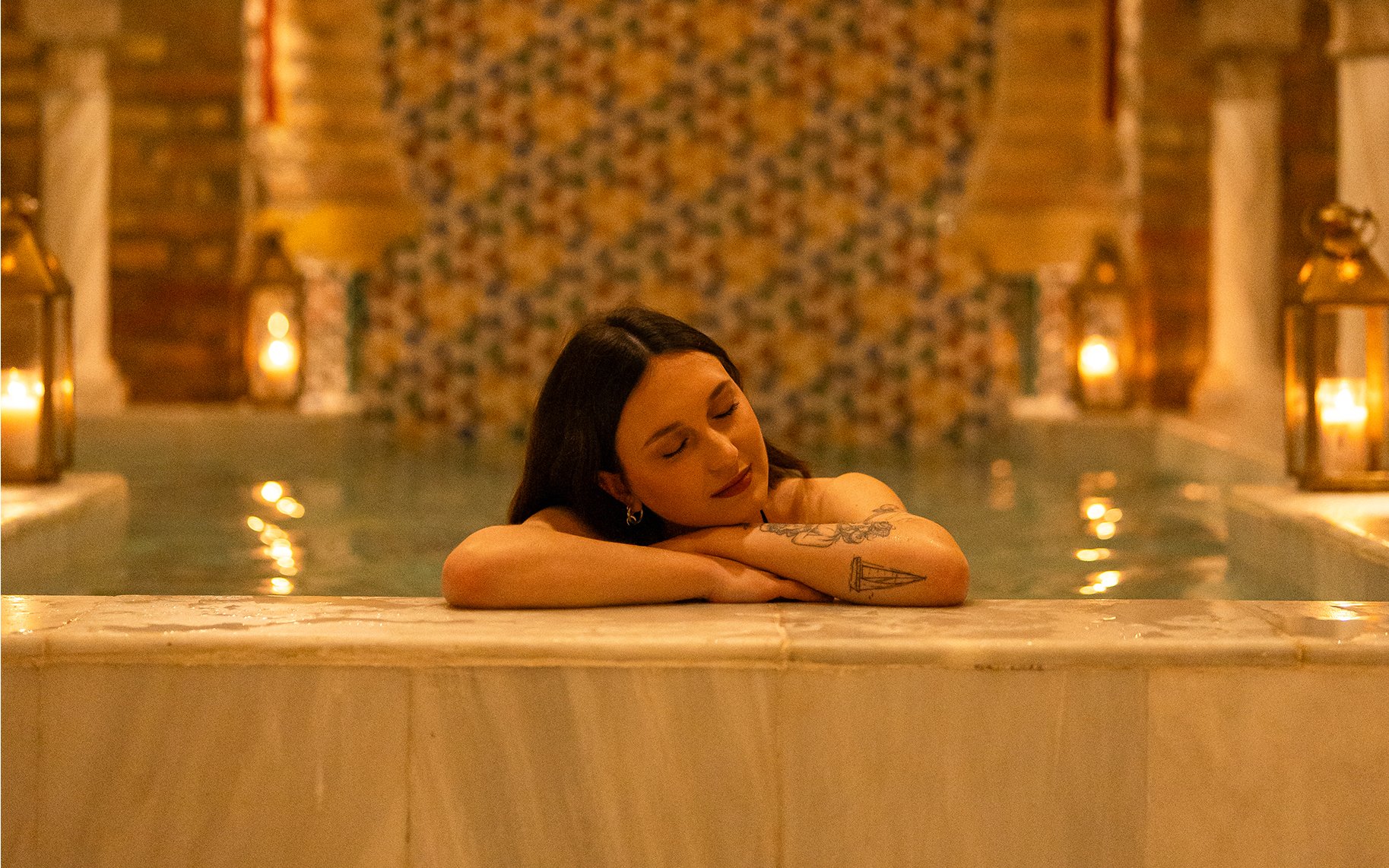 Visitors enjoying a Traditional Hammam bath in Granada, relaxing by the poolside.