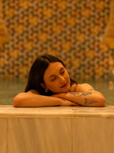 Visitors enjoying a Traditional Hammam bath in Granada, relaxing by the poolside.