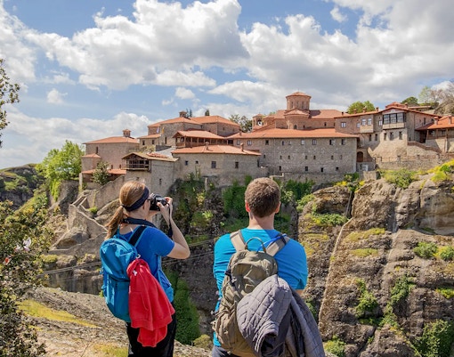 Guests hiking on a trail with Meteora rock formations in the background during a Meteora Hiking Tour with Monastery Visit.