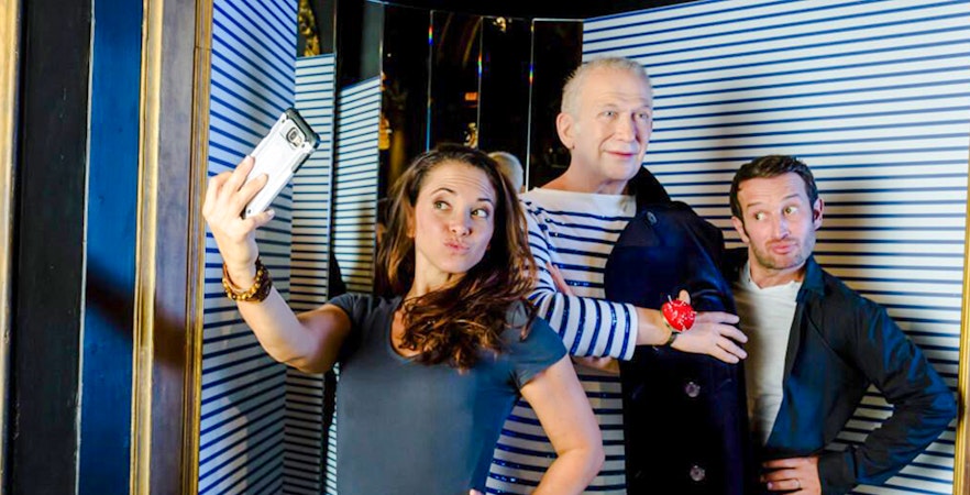 Visitors taking a selfie with Jean Paul Gaultier wax statue at Grévin Museum, Paris.