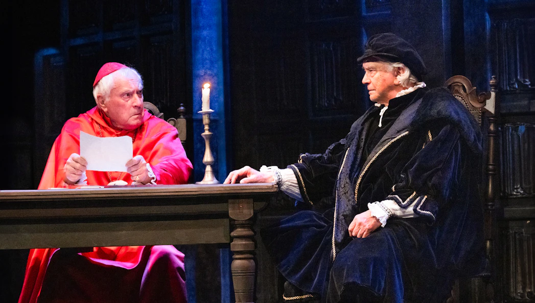 Two actors in period costumes performing a scene from "A Man For All Seasons" on stage.