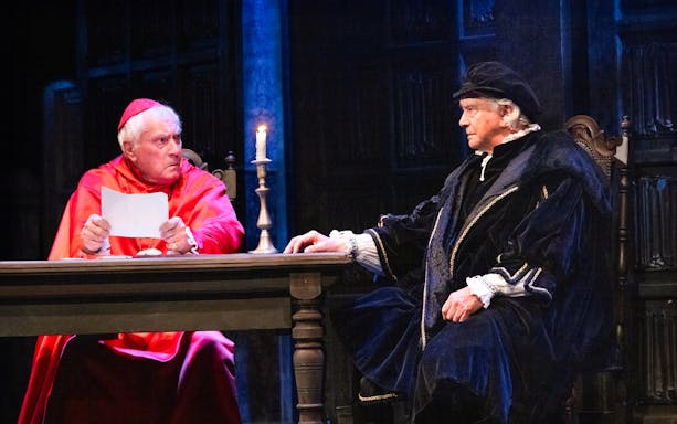 Two actors in period costumes performing a scene from "A Man For All Seasons" on stage.