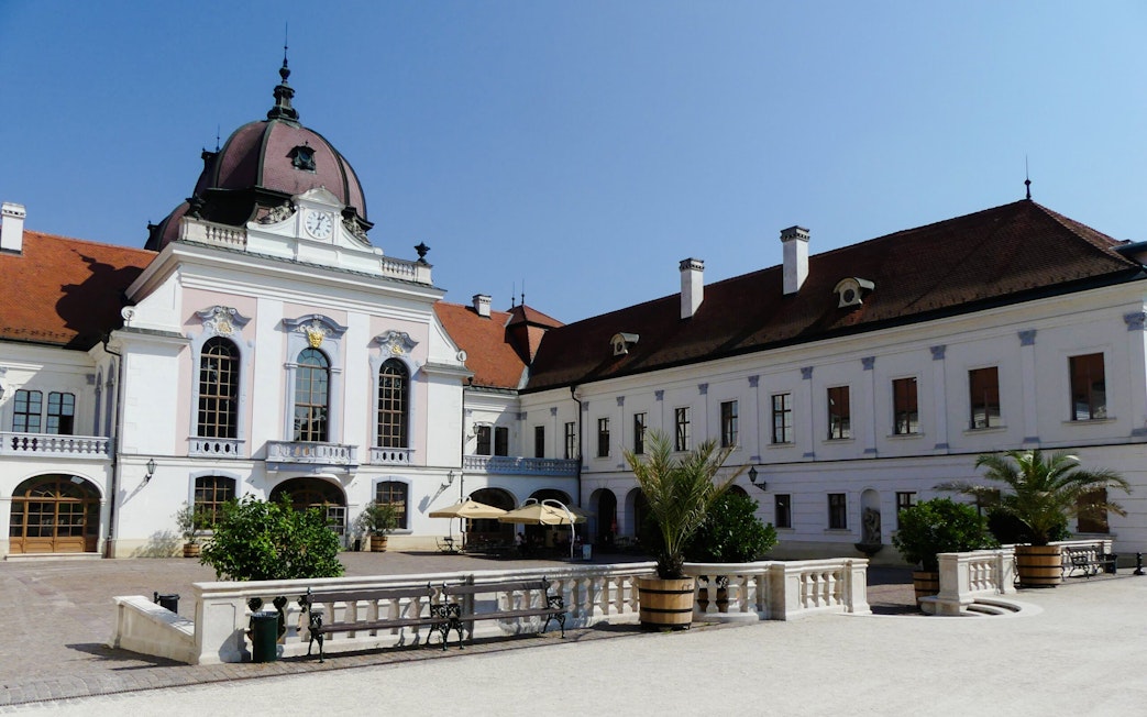 Courtyard view of Godollo Royal Palace with historic architecture and garden elements.