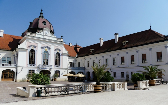 Courtyard view of Godollo Royal Palace with historic architecture and garden elements.