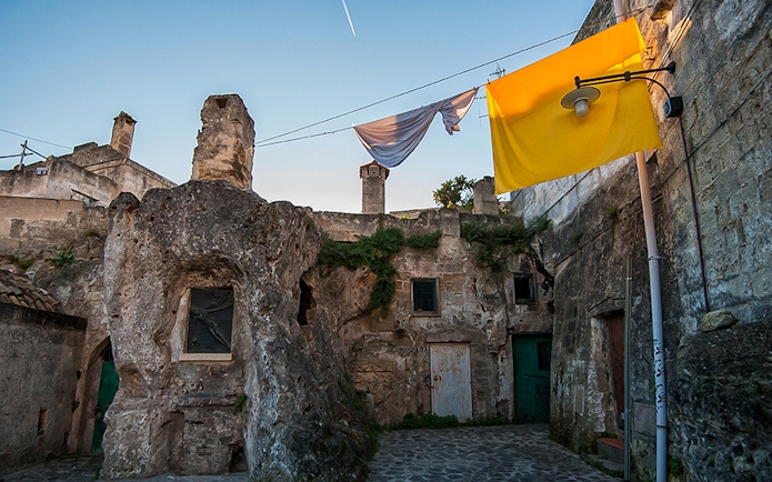 Ancient stone buildings in Sassi of Matera with laundry hanging above.