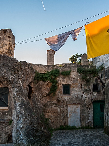 Ancient stone buildings in Sassi of Matera with laundry hanging above.