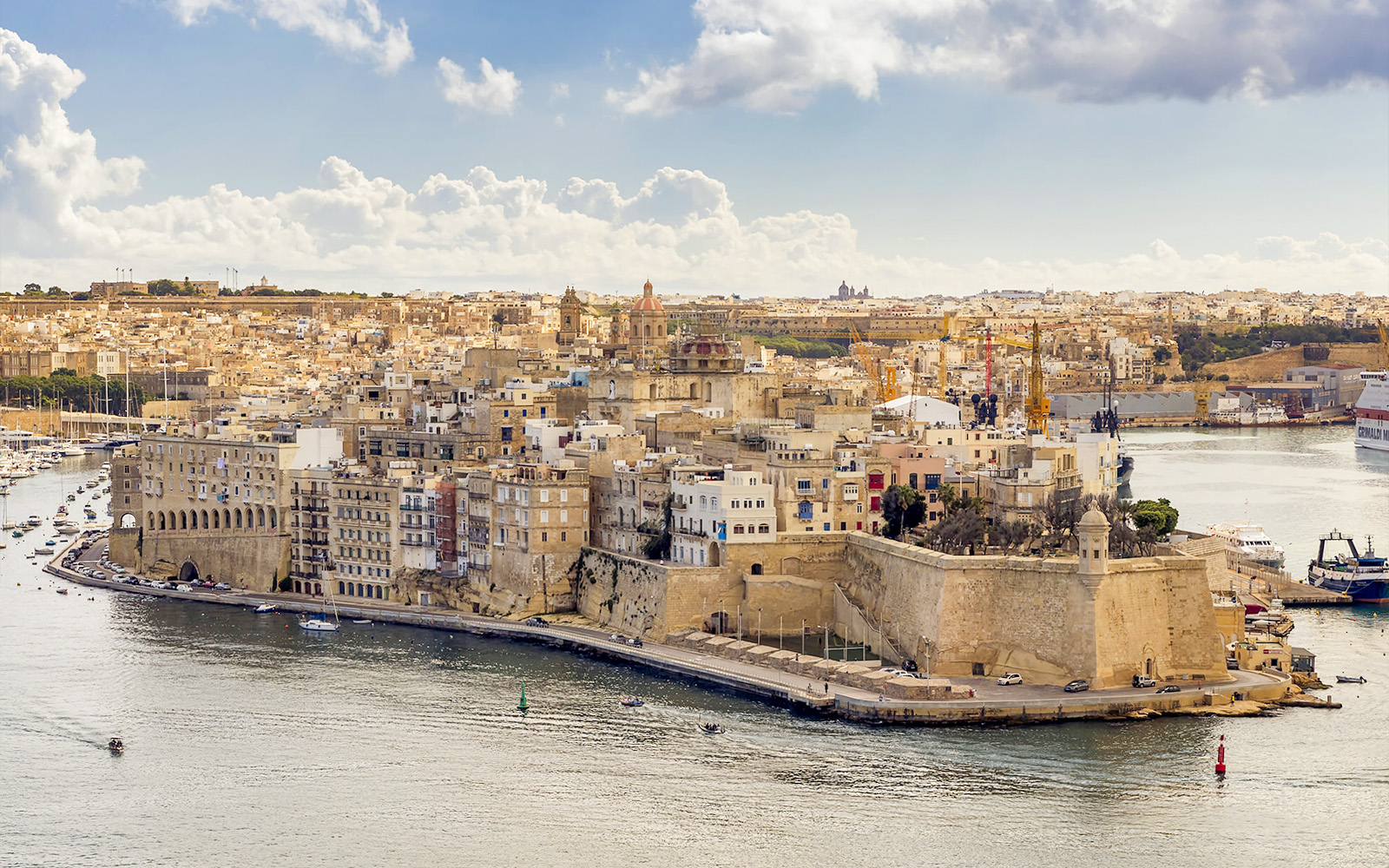 Aerial view of the Three Fortified Cities in Malta with boats in the harbor.