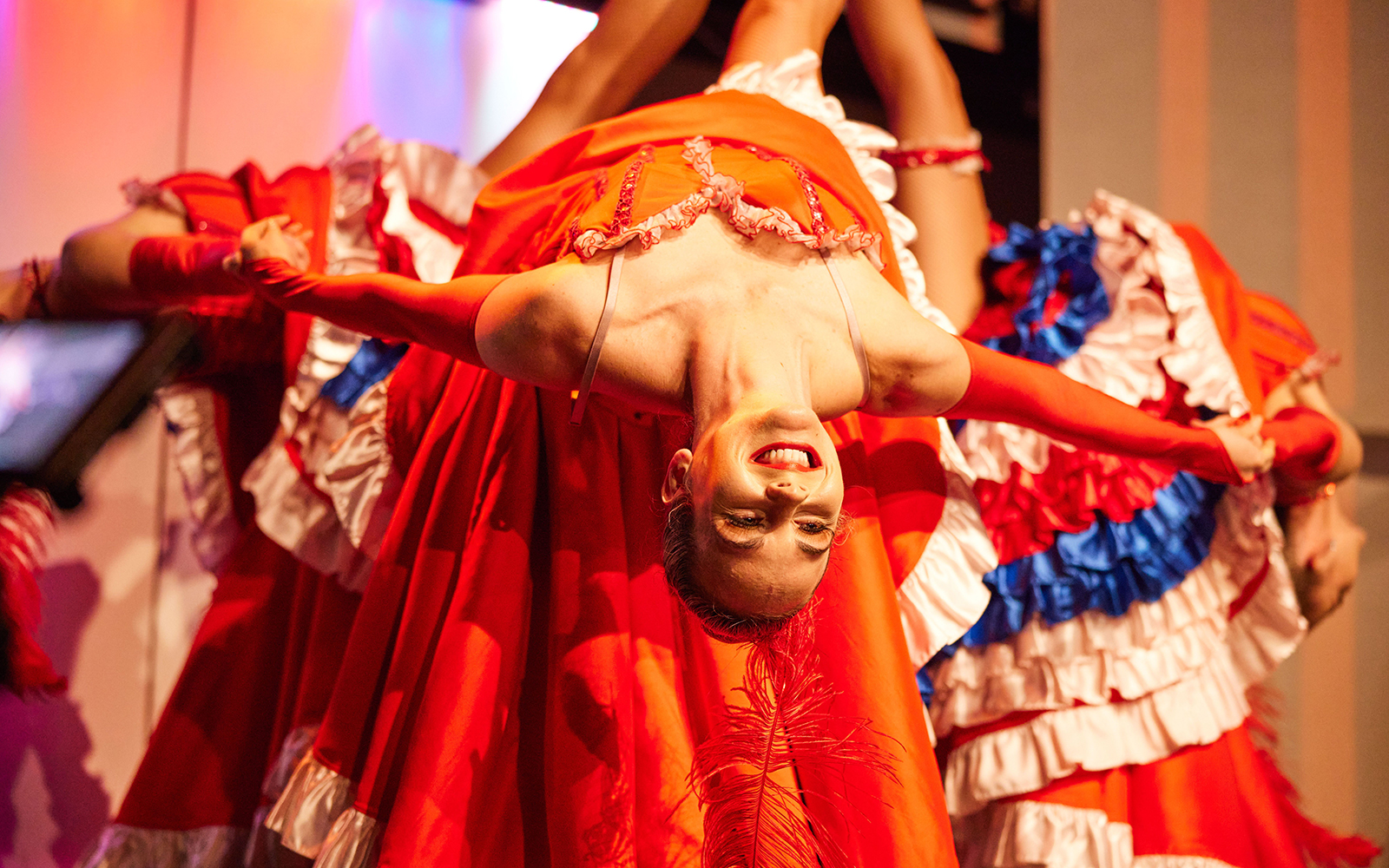 Cabaret performer in vibrant costume during cruise dinner show.