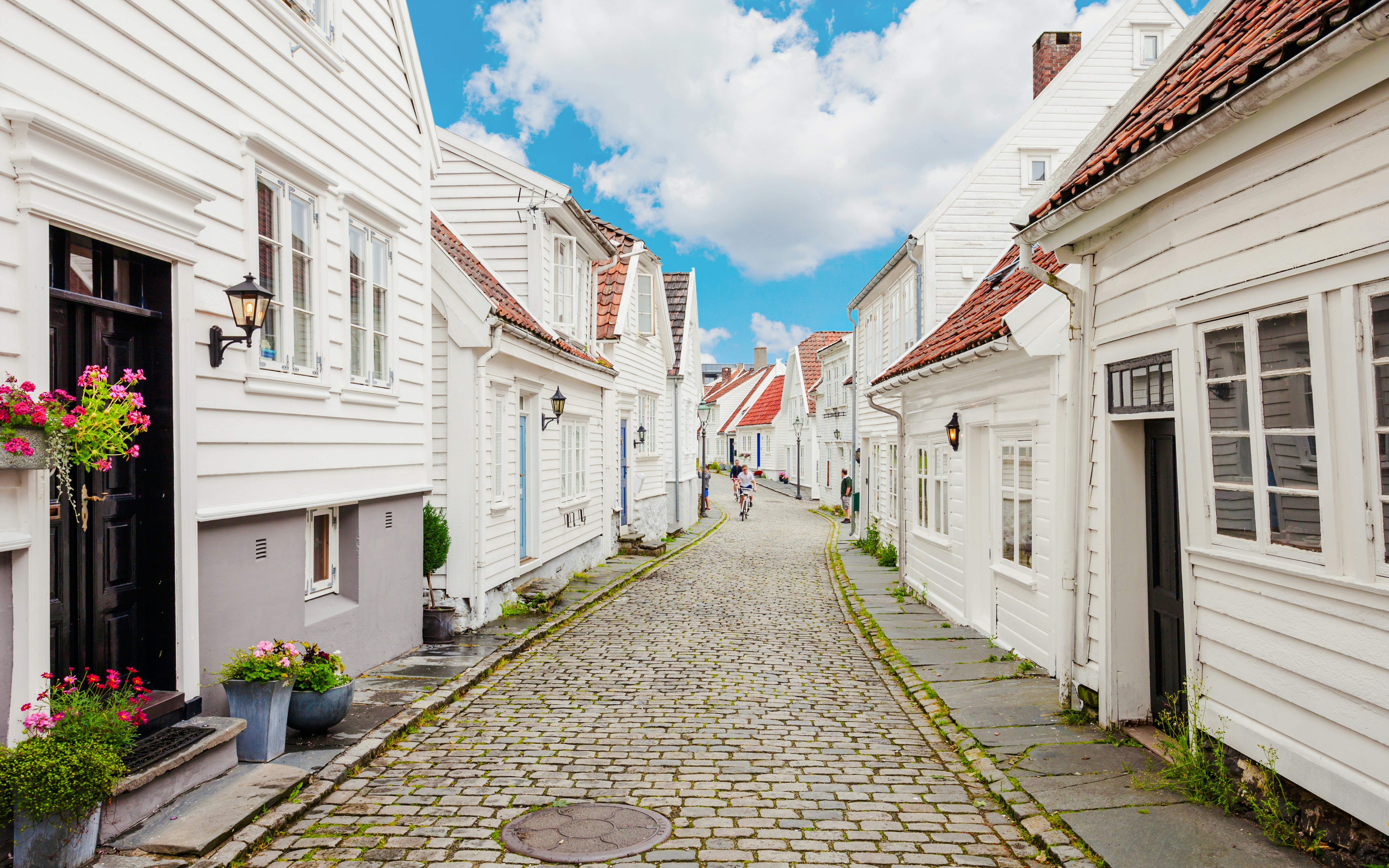 Cobblestone street lined with white wooden houses in Gamle Stavanger, Norway.