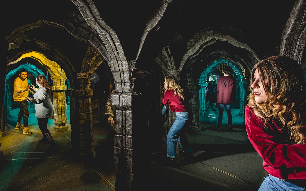 Visitors exploring the mirror maze at Edinburgh Dungeon.