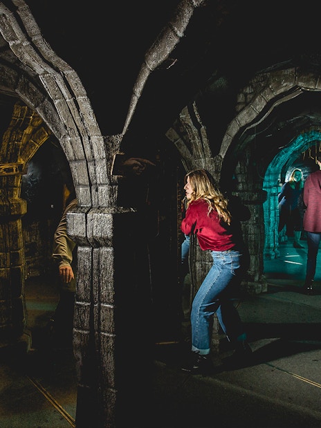 Visitors exploring the mirror maze at Edinburgh Dungeon.