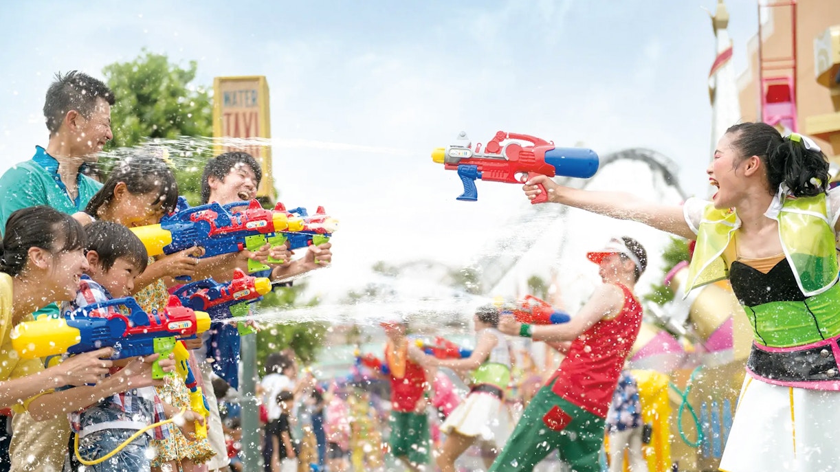 Visitors engaging in water gun battle during Summer Splash Parade at Universal Studios Japan.