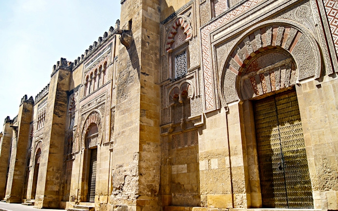 Cordoba Mosque-Cathedral exterior with intricate arches and detailed stonework.