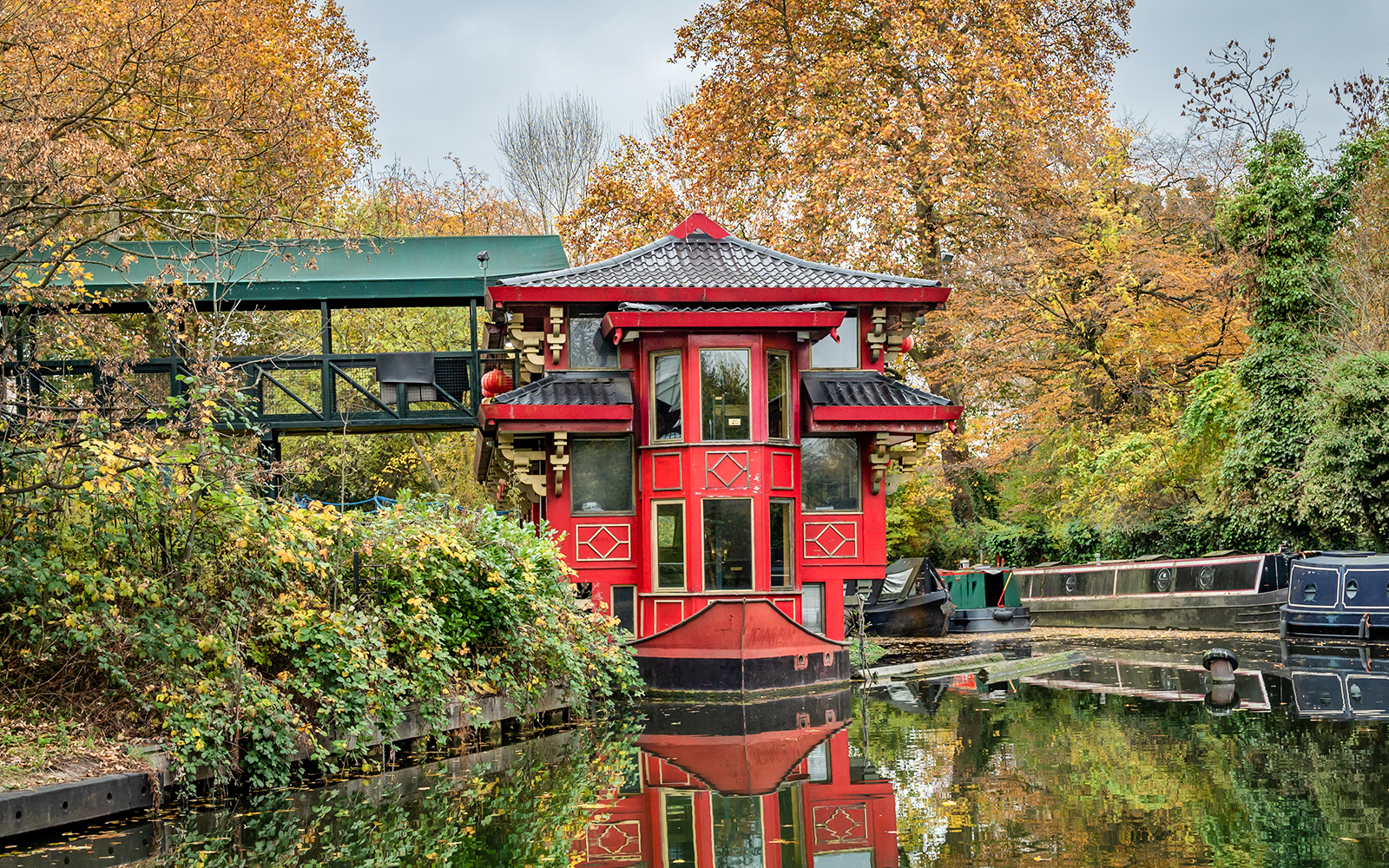 Red pagoda-style building by a canal near London Zoo in autumn.