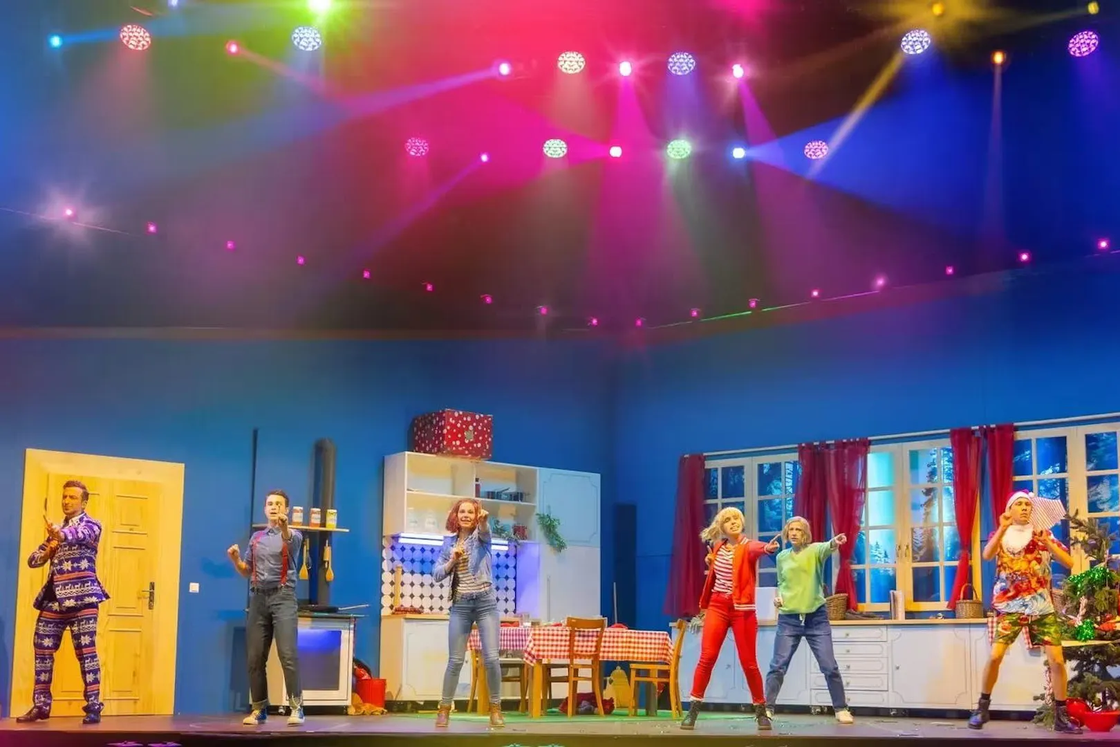 Performers on stage during Bibi & Tina musical in Berlin, colorful lights above.