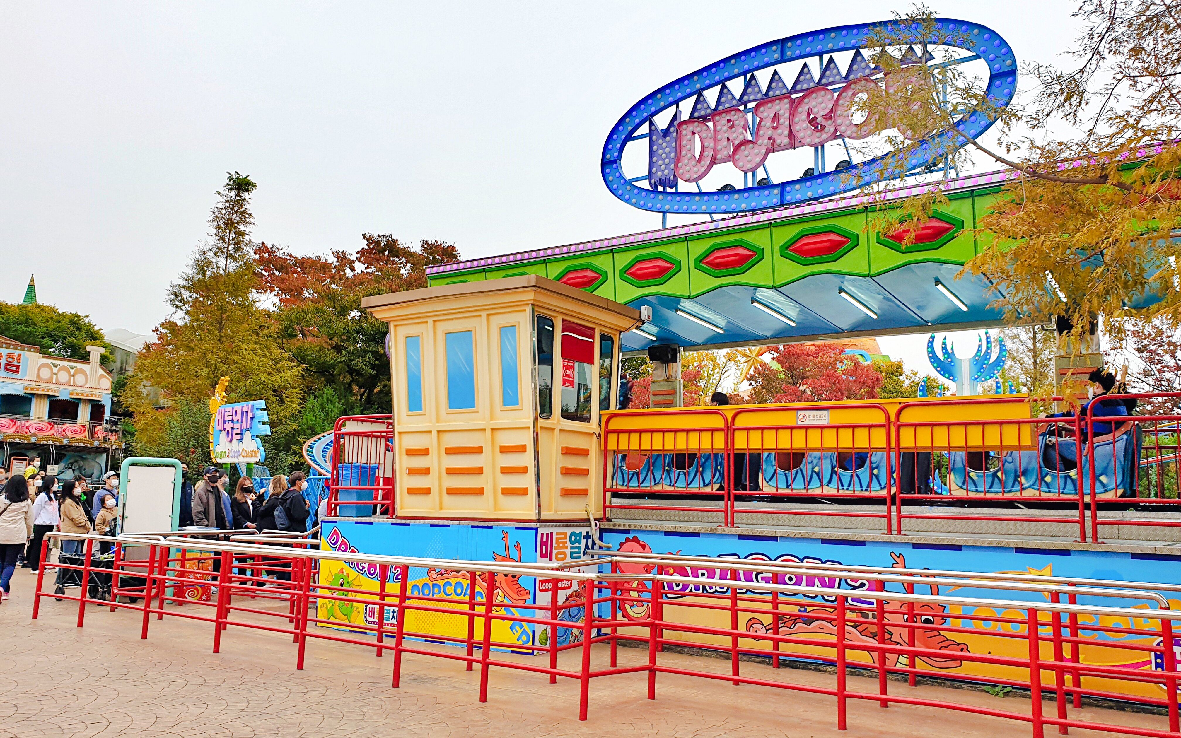 Gyeongju World amusement park ride with colorful signage and waiting visitors.
