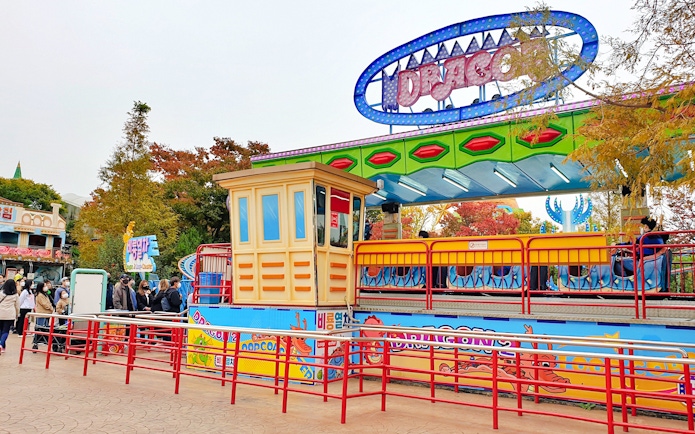 Gyeongju World amusement park ride with colorful signage and waiting visitors.