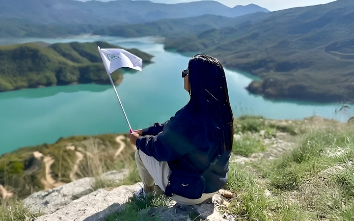 Guest overlooking Bovilla Lake with flag during 4x4 offroad tour from Tirana.