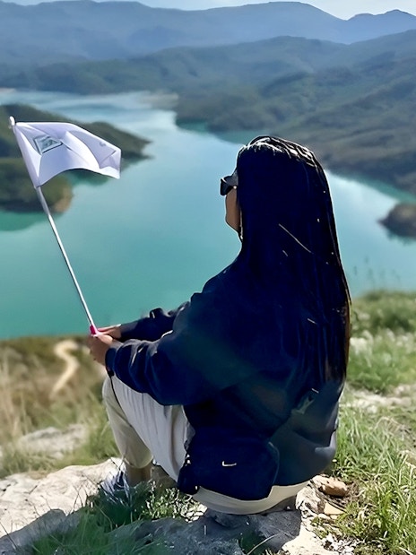 Guest overlooking Bovilla Lake with flag during 4x4 offroad tour from Tirana.
