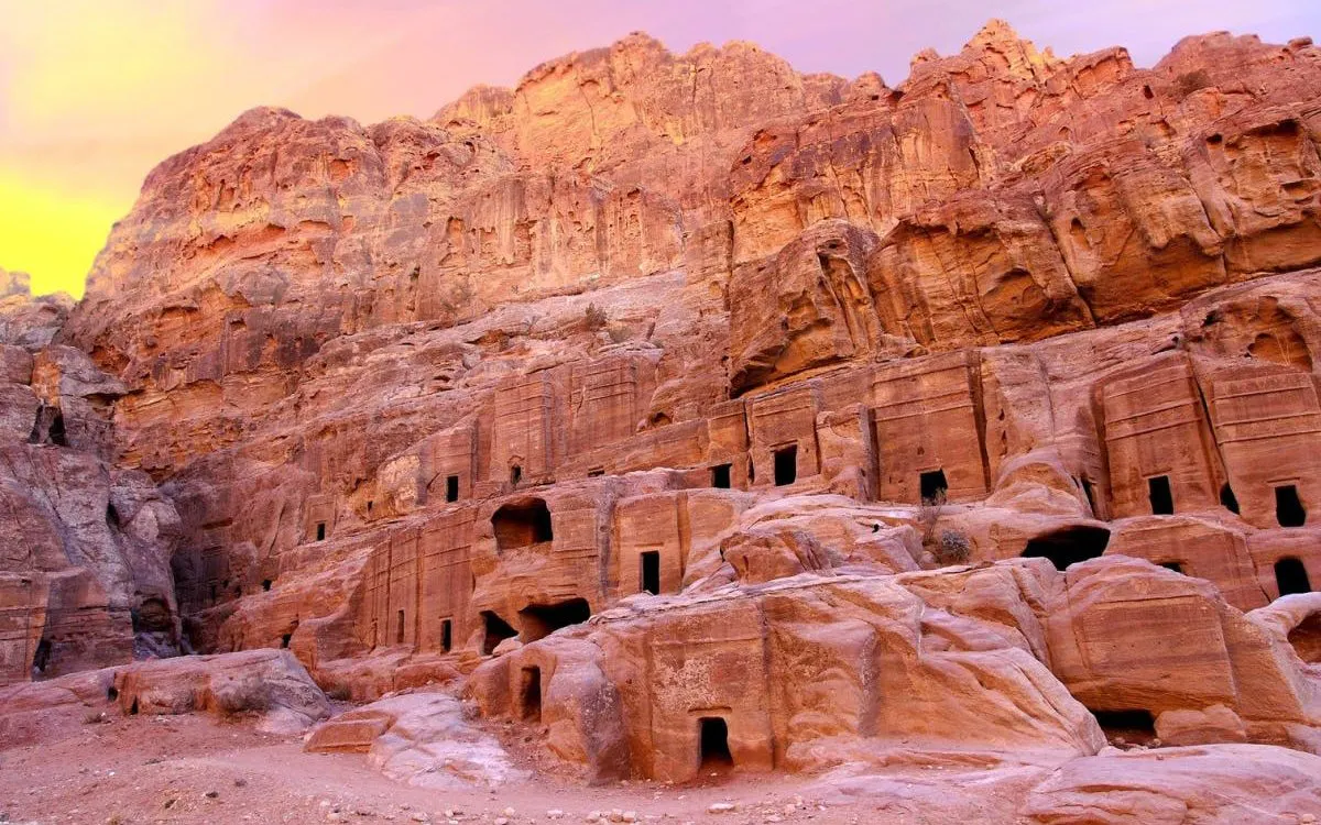 Ancient rock-cut architecture in Petra, Jordan at sunset.