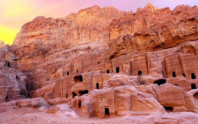 Ancient rock-cut architecture in Petra, Jordan at sunset.