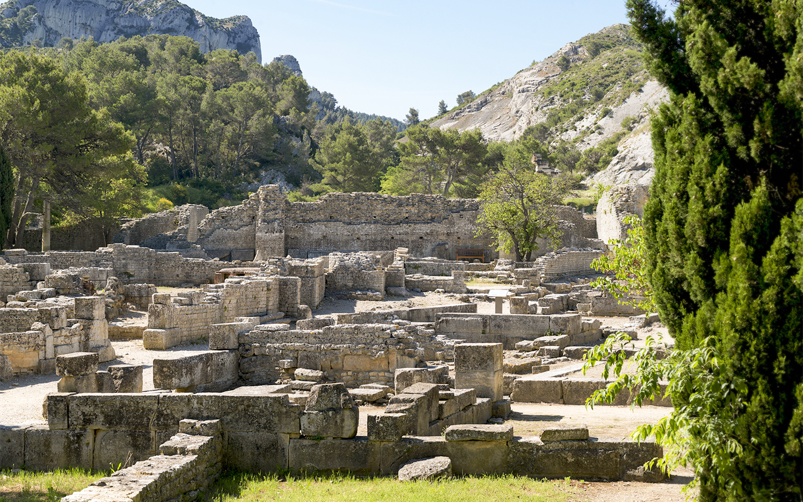 Glanum Archaeological Site ruins with stone structures and surrounding greenery in Saint-Rémy-de-Provence.