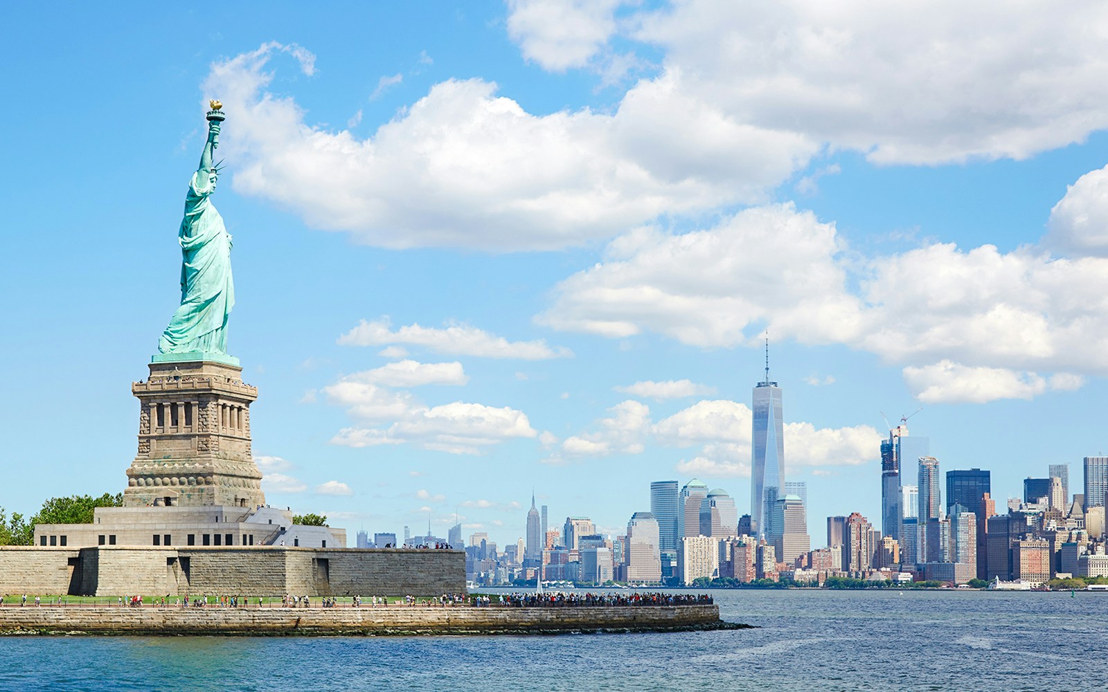 Statue of Liberty on Liberty Island with New York City skyline in the background.