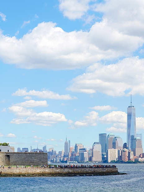 Statue of Liberty on Liberty Island with New York City skyline in the background.