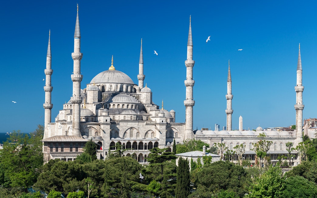 Blue Mosque exterior with minarets in Istanbul, surrounded by greenery.