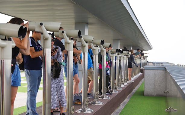 Visitors using telescopes at Korean Demilitarized Zone observation deck.