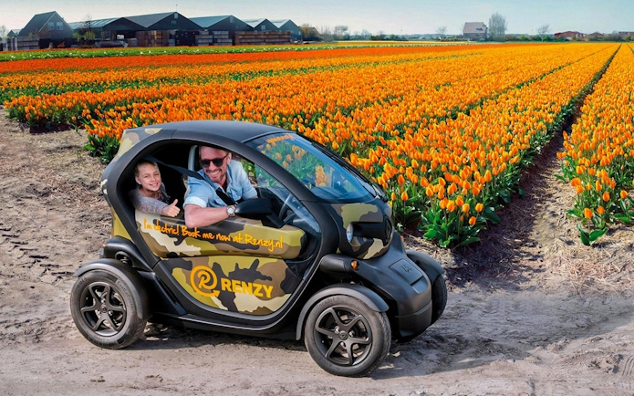 Electric car driving through tulip fields in Keukenhof during self-drive audio tour.