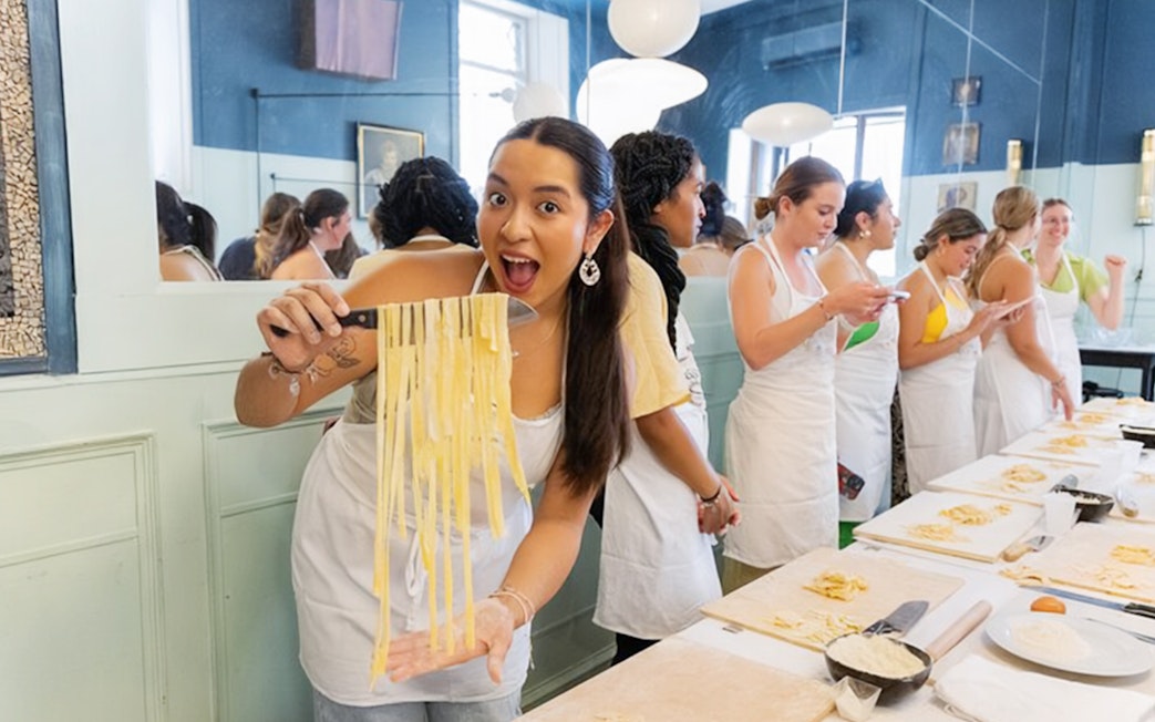 Participants making pasta at a cooking class in Rome.