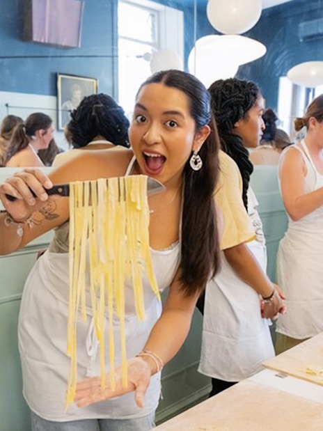 Participants making pasta at a cooking class in Rome.