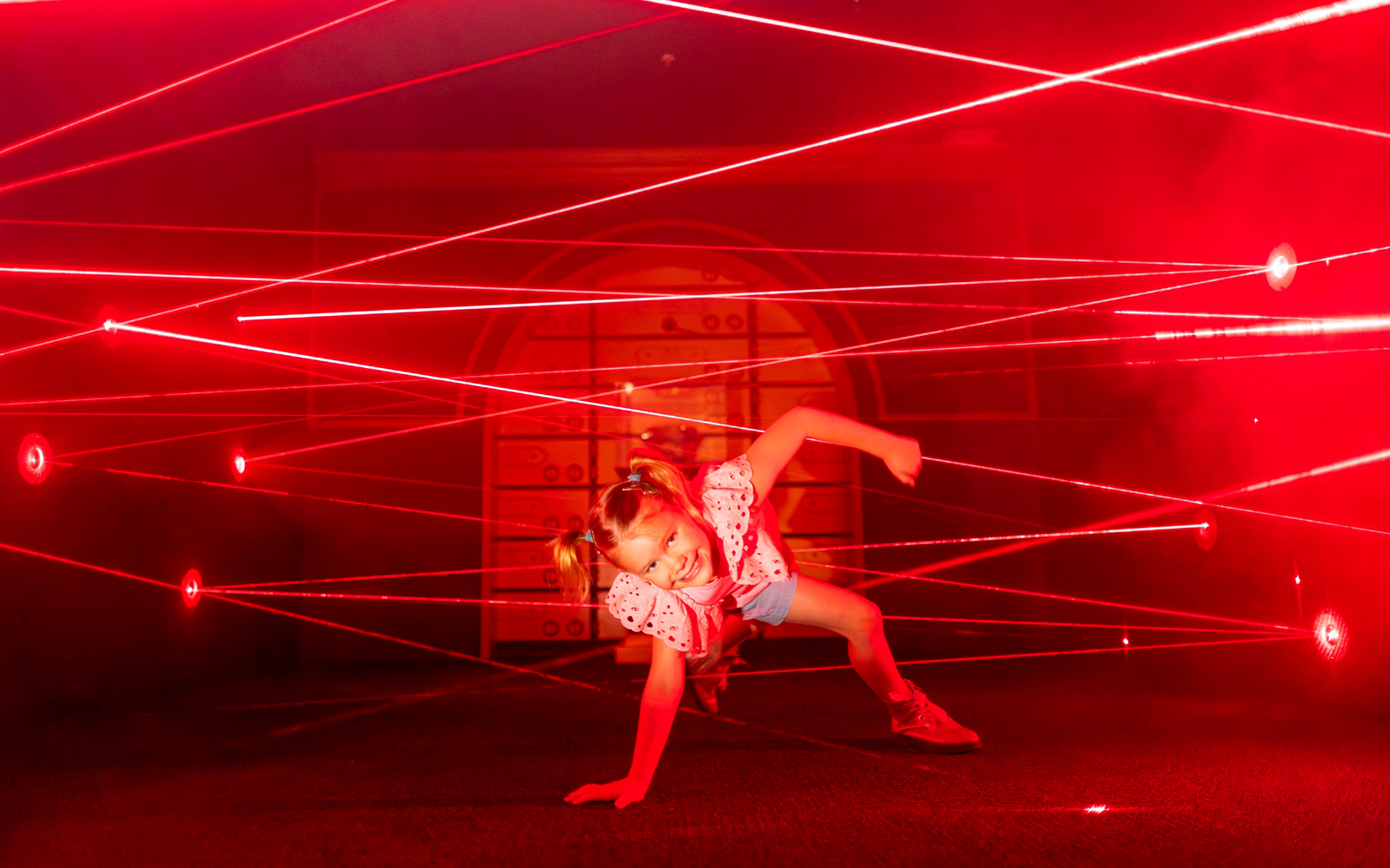 Child navigating laser maze at Monopoly Dreams Melbourne.