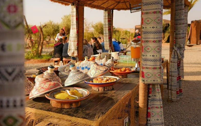 Berber breakfast setup with tagines and juice in Marrakesh during sunrise hot air balloon tour.