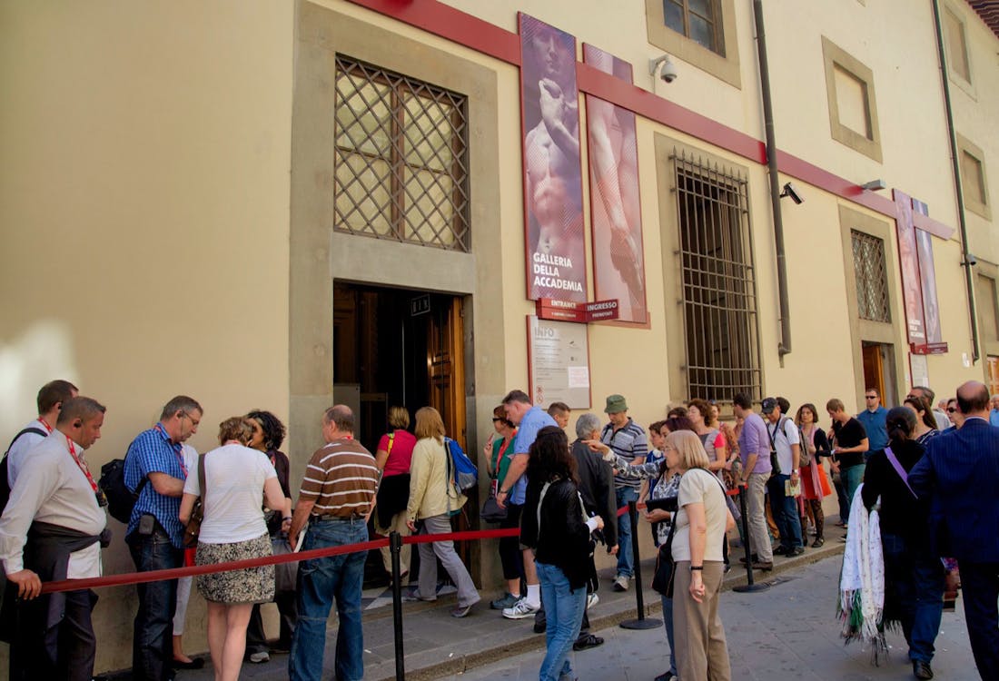 Accademia Gallery entrance in Florence with visitors waiting for a guided tour.