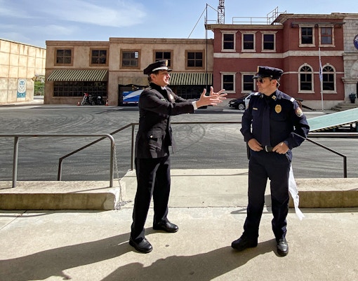 Parque Warner police show with performers in action scene, Madrid, Spain.