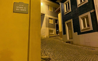 Cobbled street in Porto at night with traditional Portuguese houses.