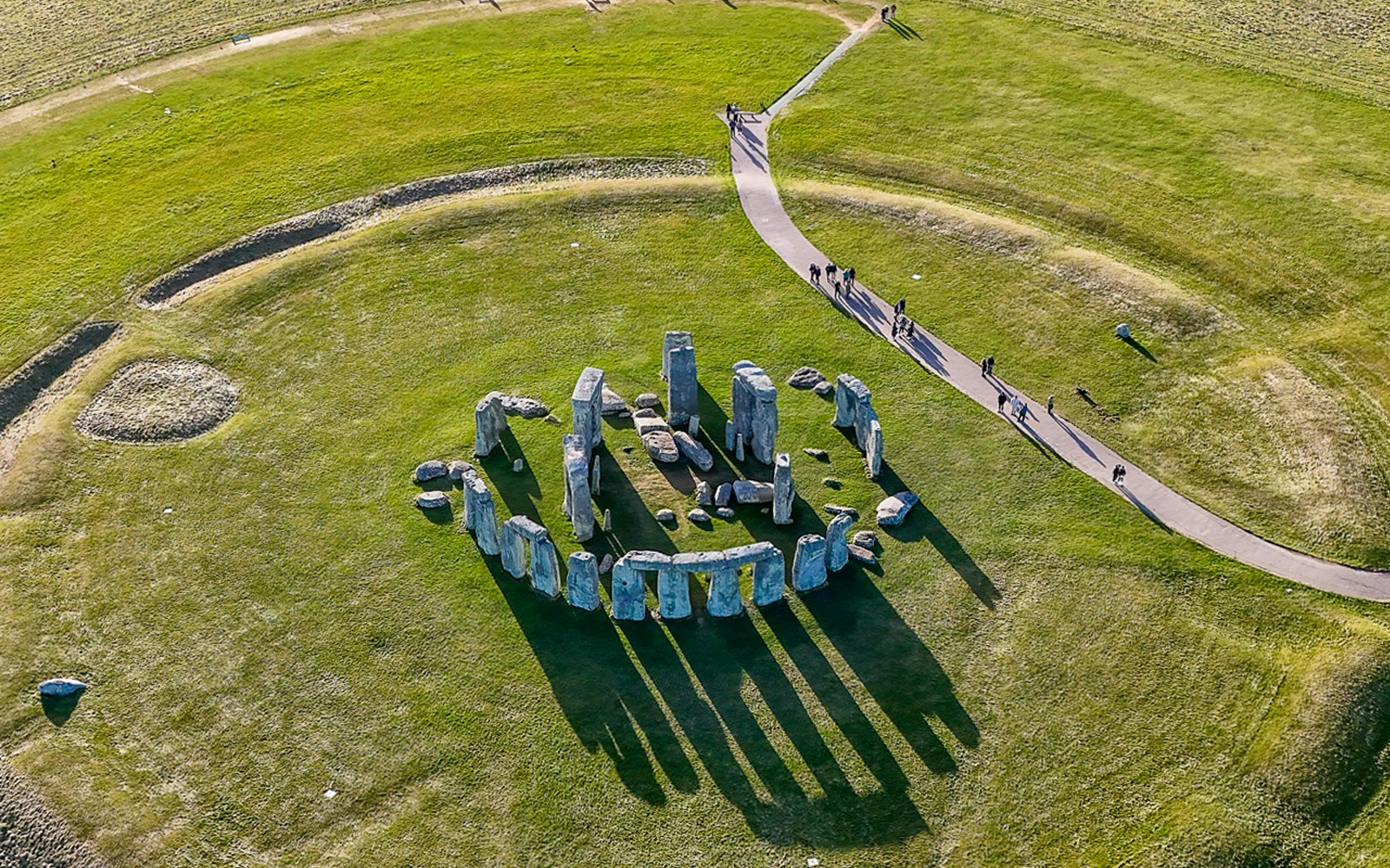 Aerial view of Stonehenge with surrounding green landscape in Wiltshire, England.