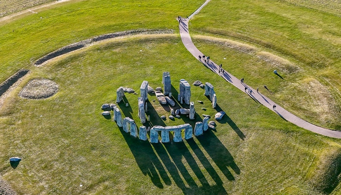 Aerial view of Stonehenge with surrounding green landscape in Wiltshire, England.