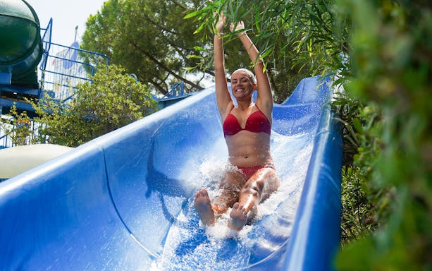 Person enjoying a water slide at Illa Fantasia Water Park, Barcelona.