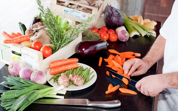 Chef preparing fresh vegetables for Bateaux Mouches Seine River lunch cruise.