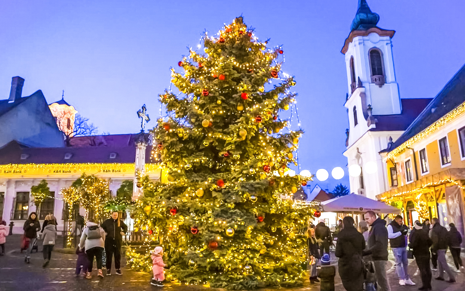 Szentendre Christmas Market with decorated tree and people enjoying the festive atmosphere.